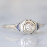 Solitario Art Déco in oro bianco 18K con diamante di taglio brillante (0.08ct ca.) e zaffiri di taglio triangolare, anni ‘30
