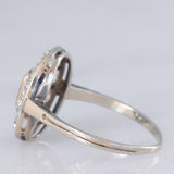 Anello a margherita antico in oro bianco con zaffiro (0.70ct ca.) e diamanti di taglio vecchia miniera (1ctw ca.), anni ‘20/‘30