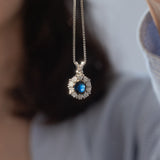 Collier vintage con ciondolo a margherita in oro bianco 14K con zaffiro (1.70ct ca.) e diamanti di taglio brillante (1.10ctw ca.), anni ‘70/‘80