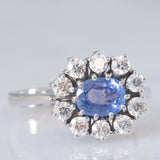Anello a margherita in oro bianco 18K con zaffiro azzurro (0.80ct ca.) e diamanti di taglio brillante (0.70ctw ca.), anni ‘70/‘80