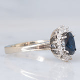 Anello a margherita in oro bianco 18K con zaffiro (1.30ct ca.) e diamanti di taglio brillante (0.44ctw ca.), anni ‘70