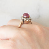 Anello a margherita vintage in oro giallo e bianco 14K con rubino (2.60ct ca.) e diamanti di taglio brillante (0.70ctw ca.), anni ‘60