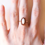 Anello a margherita vintage in oro giallo 9K con opale (0.80ctw ca.) e granati (0.35ctw ca.), anno 1980