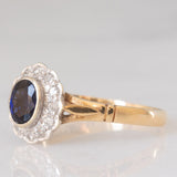 Anello a margherita vintage in oro giallo e bianco 9K con zaffiro (0.60ct ca.) e diamanti (0.12ctw ca.), anno 1991