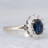 Anello a margherita in oro bianco 18K con zaffiro (1.30ct ca.) e diamanti di taglio brillante (0.44ctw ca.), anni ‘70