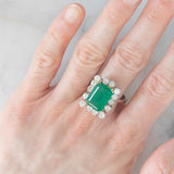 Anello a margherita vintage in oro bianco 14K con smeraldo (5.50ct ca.) e diamanti di taglio brillante (1.65ctw ca.), anni ‘70