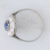 Anello a margherita antico in oro bianco con zaffiro (0.70ct ca.) e diamanti di taglio vecchia miniera (1ctw ca.), anni ‘20/‘30