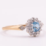 Anello a margherita vintage in oro giallo 9K con topazio azzurro (0.45ct ca.) e diamanti (0.14ctw ca.), anni ‘90