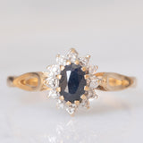 Anello a margherita vintage in oro giallo e bianco 9K con zaffiro (0.60ct ca.) e diamanti (0.06ctw ca.), anno 1988