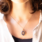 Ciondolo portafoto antico di forma ovale con lamina in oro giallo 9K su metallo e con smalti blu, primi del ‘900