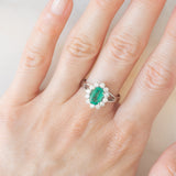 Anello a margherita in oro bianco 18K con smeraldo (1ct ca.) e diamanti di taglio brillante (0.50ctw ca.), anni ‘60
