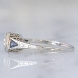Solitario Art Déco in oro bianco 18K con diamante di taglio brillante (0.08ct ca.) e zaffiri di taglio triangolare, anni ‘30