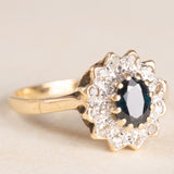 Anello a margherita vintage in oro giallo e bianco 9K con zaffiro (0.60ct ca.) e diamanti (0.12ctw ca.), anno 1982
