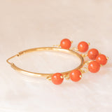 Orecchini a cerchio in oro giallo 18K con sfere di corallo arancione pendenti, anni ‘60