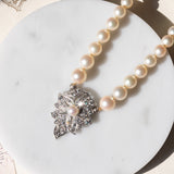 Collana vintage con filo di perle bianche e con decorazioni in oro bianco 18K e 14K con diamanti (1.20ctw ca.) e zaffiro (0.40ct ca.), anni ‘60