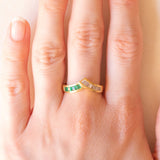 Anello a “V” vintage in oro giallo 18K con smeraldi di taglio carré (0.28ctw ca.) e diamanti di taglio tapered (0.25ctw ca.), anni ‘70/‘80