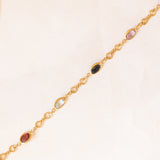 Bracciale vintage in oro giallo 18K con granati, ametiste, acquamarina, spinello blu sintetico e zaffiro bianco, anni ‘70