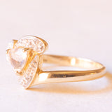 Anello in oro giallo e bianco 9K con zaffiro rosa chiaro sintetico di taglio trillion (0.65ct ca.) e zaffiri bianchi, anni ‘80