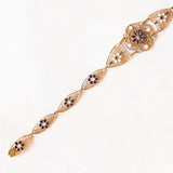 Braccialetto semirigido in oro giallo 14K con decorazioni floreali con smalti bianchi, rossi, verdi e blu e con lavorazioni a traforo, anni ‘50/‘60