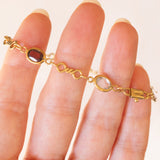 Bracciale vintage in oro giallo 18K con granati, ametiste, acquamarina, spinello blu sintetico e zaffiro bianco, anni ‘70