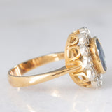 Anello a margherita vintage in oro 18K con zaffiro (1.10ct ca.) e diamanti di taglio brillante (0.50ctw ca.), anni ‘60