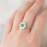 Anello a margherita vintage in oro bianco 18K con smeraldo (0.50ct ca.) e diamanti di taglio brillante (1.20ctw ca.), anni ‘60/‘70
