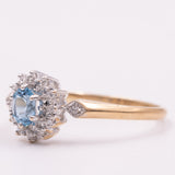 Anello a margherita vintage in oro giallo 9K con topazio azzurro (0.45ct ca.) e diamanti (0.14ctw ca.), anni ‘90