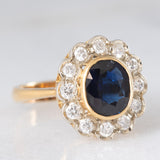 Anello a margherita vintage in oro 18K con zaffiro (1.10ct ca.) e diamanti di taglio brillante (0.50ctw ca.), anni ‘60