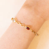 Bracciale vintage in oro giallo 18K con granati, ametiste, acquamarina, spinello blu sintetico e zaffiro bianco, anni ‘70