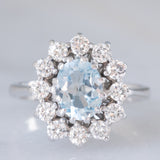 Anello a margherita in oro bianco 18K con acquamarina (1.10ct ca.) e diamanti di taglio brillante (1ctw ca.), anni ‘70