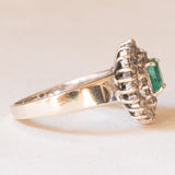 Anello a margherita vintage in oro bianco 18K con smeraldo (0.50ct ca.) e diamanti (0.53ctw ca.), anni ‘60/‘70