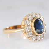 Anello a margherita vintage in oro 18K con zaffiro (1.10ct ca.) e diamanti di taglio brillante (0.50ctw ca.), anni ‘60