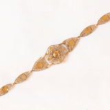 Braccialetto semirigido in oro giallo 14K con decorazioni floreali con smalti bianchi, rossi, verdi e blu e con lavorazioni a traforo, anni ‘50/‘60