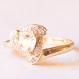 Anello in oro giallo e bianco 9K con zaffiro rosa chiaro sintetico di taglio trillion (0.65ct ca.) e zaffiri bianchi, anni ‘80