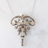 Collana con pendente/spilla Art Nouveau in oro giallo 18K e argento con diamanti di taglio rosetta (0.50ctw ca.), rubini e perle bianche, anni ‘10/‘20