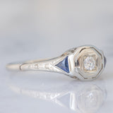 Solitario Art Déco in oro bianco 18K con diamante di taglio brillante (0.08ct ca.) e zaffiri di taglio triangolare, anni ‘30