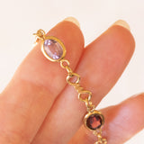 Bracciale vintage in oro giallo 18K con granati, ametiste, acquamarina, spinello blu sintetico e zaffiro bianco, anni ‘70