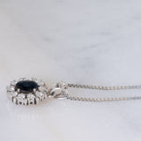 Collier vintage con ciondolo a margherita in oro bianco 14K con zaffiro (1.70ct ca.) e diamanti di taglio brillante (1.10ctw ca.), anni ‘70/‘80