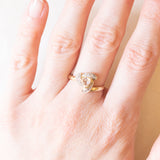 Anello in oro giallo e bianco 9K con zaffiro rosa chiaro sintetico di taglio trillion (0.65ct ca.) e zaffiri bianchi, anni ‘80