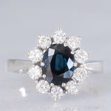 Anello a margherita vintage in oro bianco 18K con zaffiro (1.90ct ca.) e diamanti di taglio brillante (0.75ctw ca.), anni ‘70