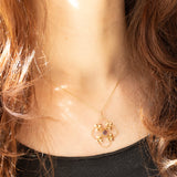 Pendente antico lavalier in oro giallo 9K con pasta di vetro viola e con decorazioni a forma di foglie, anni ‘10