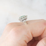 Anello a margherita in oro bianco 18K con smeraldo (1ct ca.) e diamanti di taglio brillante (0.50ctw ca.), anni ‘60