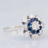 Anello a fiore vintage in oro bianco 14K con zaffiri (0.32ctw ca.) e diamanti di taglio brillante (0.84ctw ca.), anni ‘70