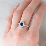 Anello a margherita vintage in oro bianco 14K con zaffiro (1.15ct ca.) e diamanti di taglio brillante (0.48ctw ca.), anni ‘80