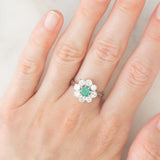Anello a margherita vintage in oro bianco 18K con smeraldo (0.50ct ca.) e diamanti di taglio brillante (1.20ctw ca.), anni ‘60/‘70
