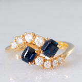 Toi et Moi francese vintage in oro giallo 18K con zaffiri di taglio smeraldo (0.80ct ca.) e diamanti di taglio brillante (0.20ct ca.), anni ‘70