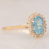 Anello a margherita vintage in oro giallo 9K con topazio azzurro (1.50ct ca.) e diamanti (0.10ctw ca.), anno 1988