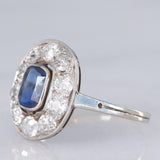 Anello a margherita antico in oro bianco con zaffiro (0.70ct ca.) e diamanti di taglio vecchia miniera (1ctw ca.), anni ‘20/‘30