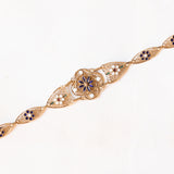 Braccialetto semirigido in oro giallo 14K con decorazioni floreali con smalti bianchi, rossi, verdi e blu e con lavorazioni a traforo, anni ‘50/‘60