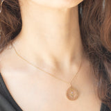 Ciondolo antico in oro giallo 9K con decorazioni naturalistiche e con rodine decorato da perline bianche e da ametista, anni ‘10/‘20